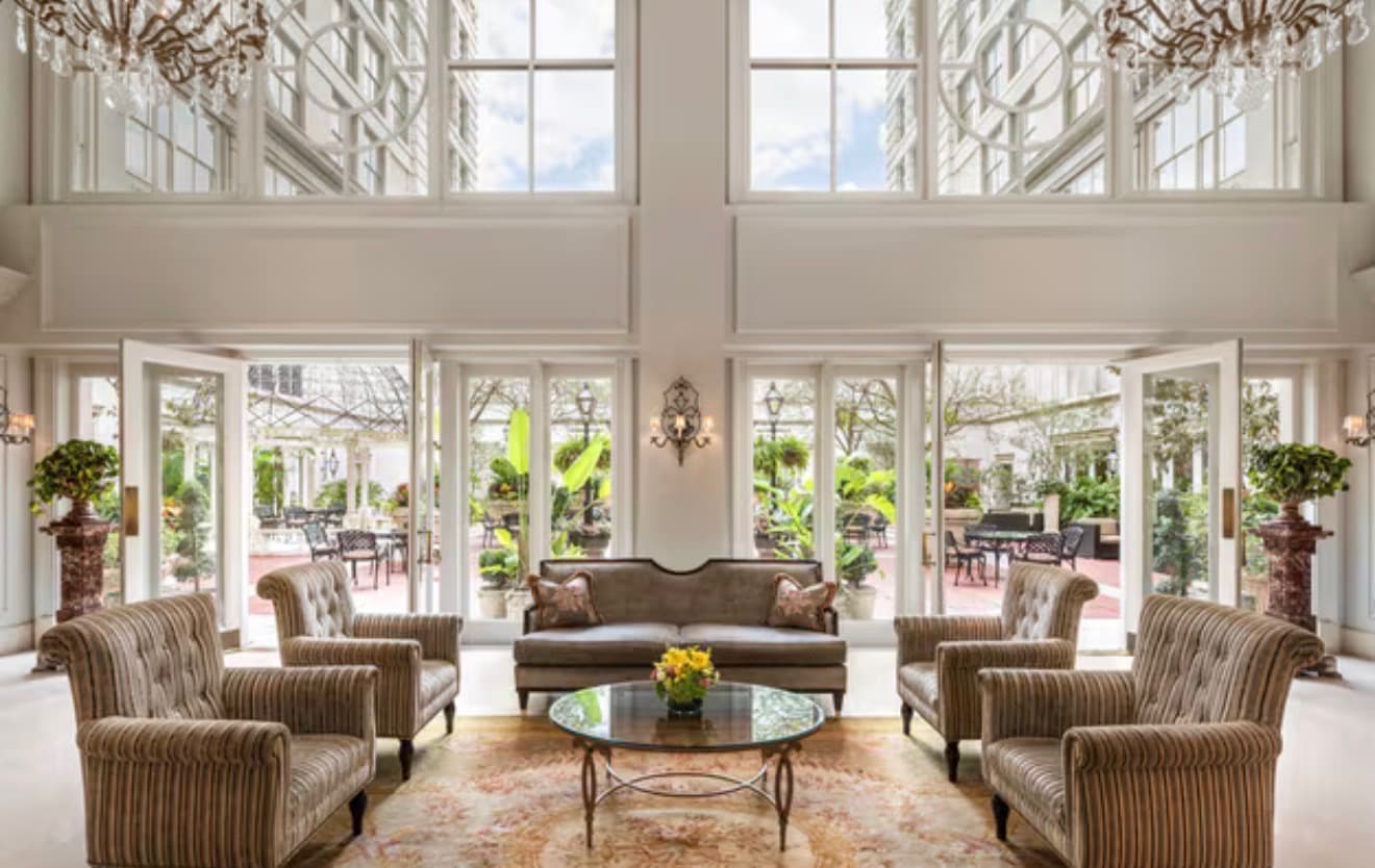 The sunlit lobby atrium with chandeliers and garden courtyard